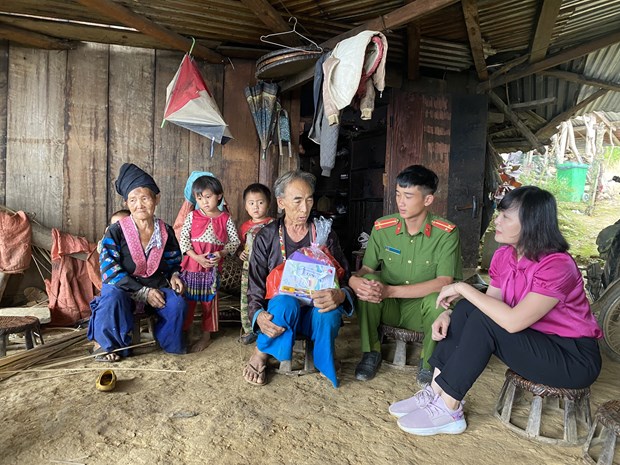 Cán bộ Văn phòng Thường trực Ban Chỉ đạo về Nhân quyền Chính phủ và chiến sĩ Công an xã Tà Tổng thăm hỏi gia đình ông Mùa Gạ Chu. (Ảnh: PV/Vietnam+)