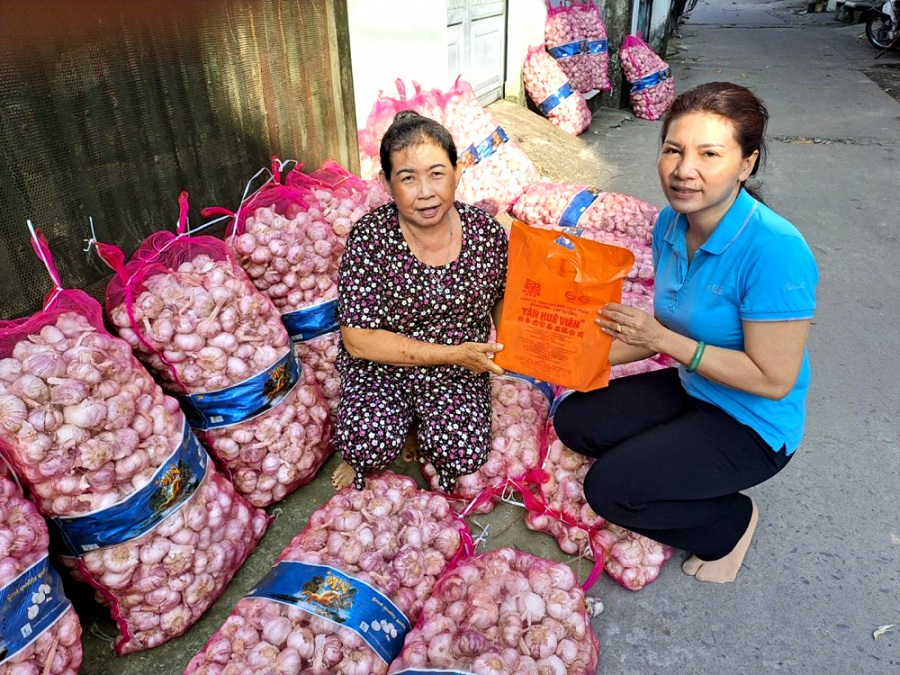 Chị Vân (phải) ghé thăm, tặng quà cho bà Oanh, người đang phải vật lộn kiếm tiền nuôi hai đứa cháu mồ côi.